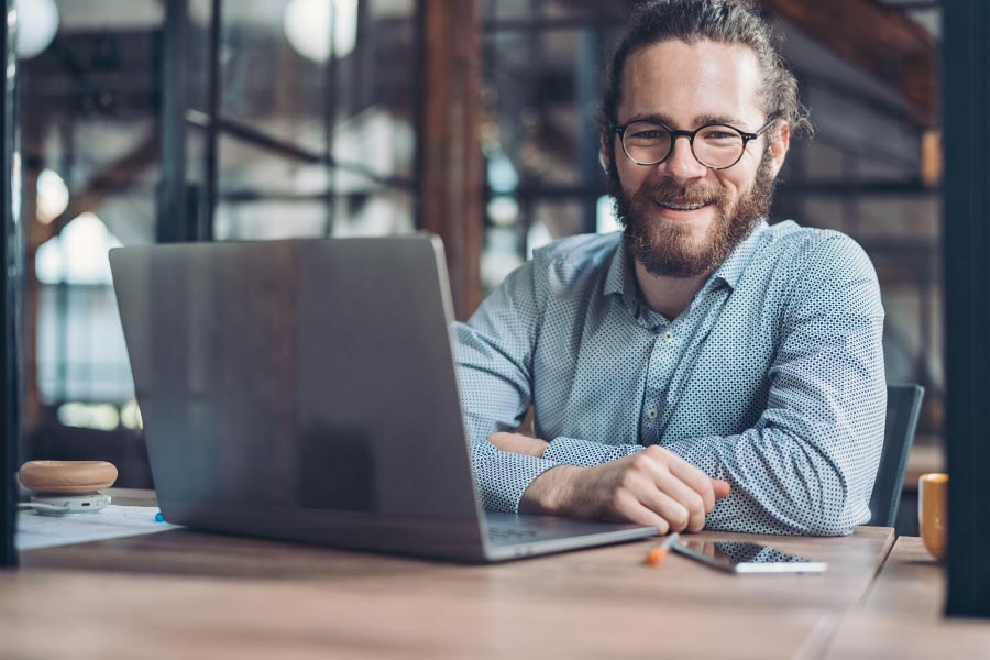 Middle aged man with braces working at a computer.