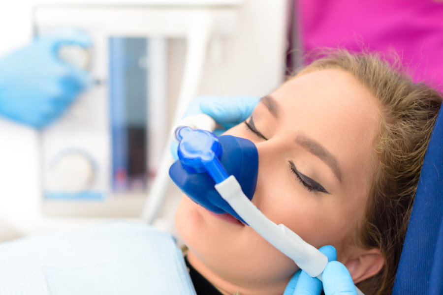 Women wearing a mask to receive nitrous oxide sedation to help with dental anxiety.