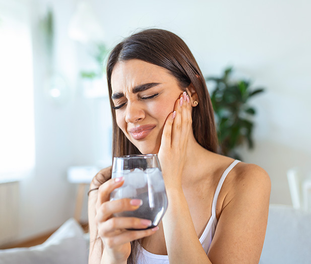 woman holding her jaw in pain