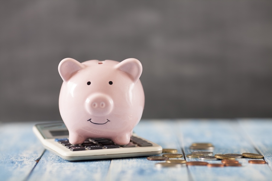 image of piggy bank on calculator to indicate savings from maximizing an in house dental plan