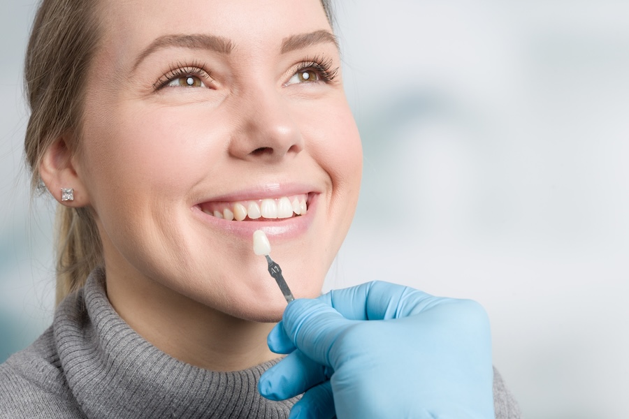 woman getting shade matched during dental veneers process